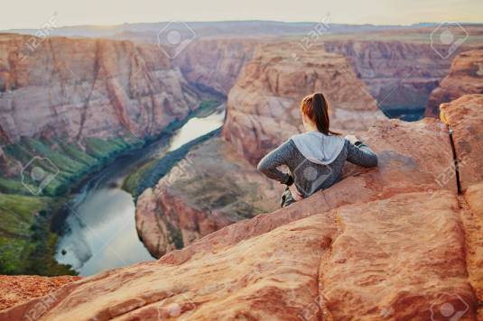 Woman standing on precipice edge at Horseshoe Bend, Arizona, USA